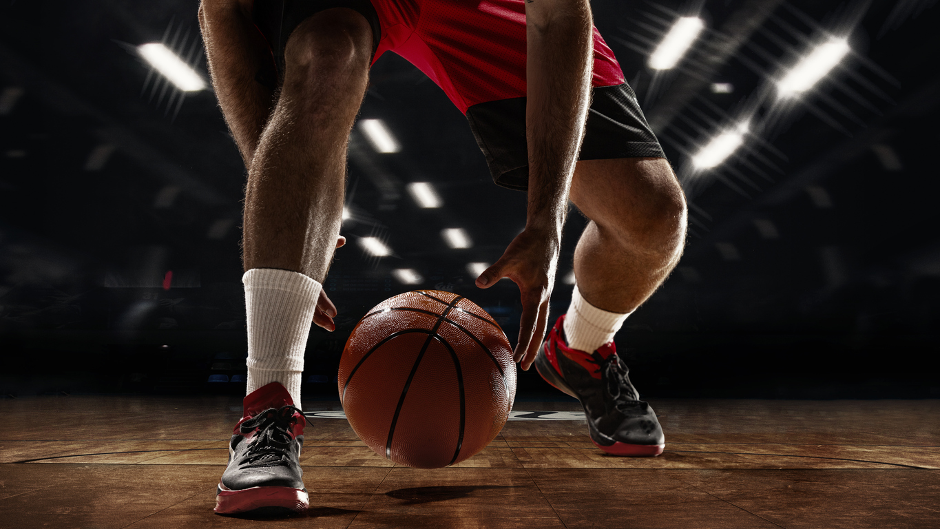 Basketball player dribbling the ball on a hardwood