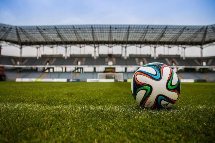 A football on the ground of an empty soccer stadium
