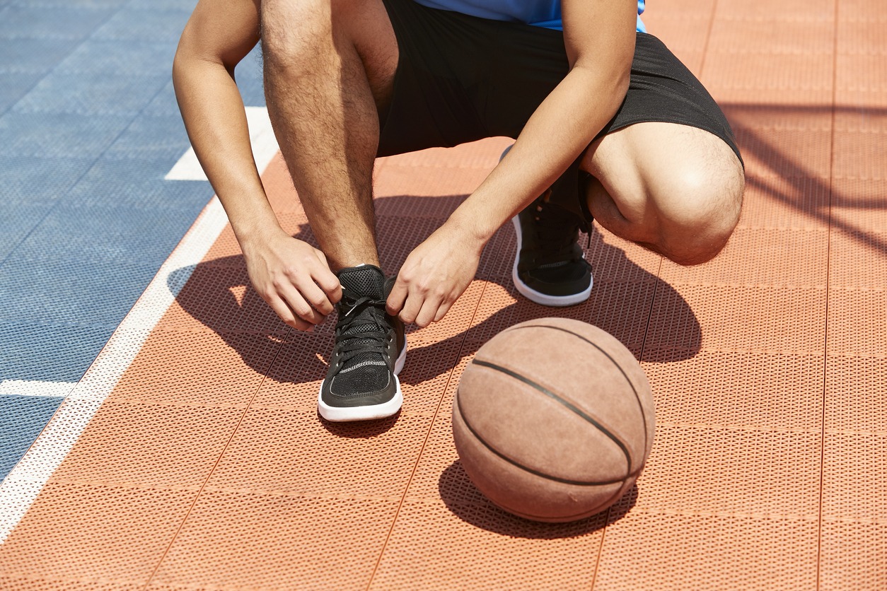 lacing up a pair of basketball shoes