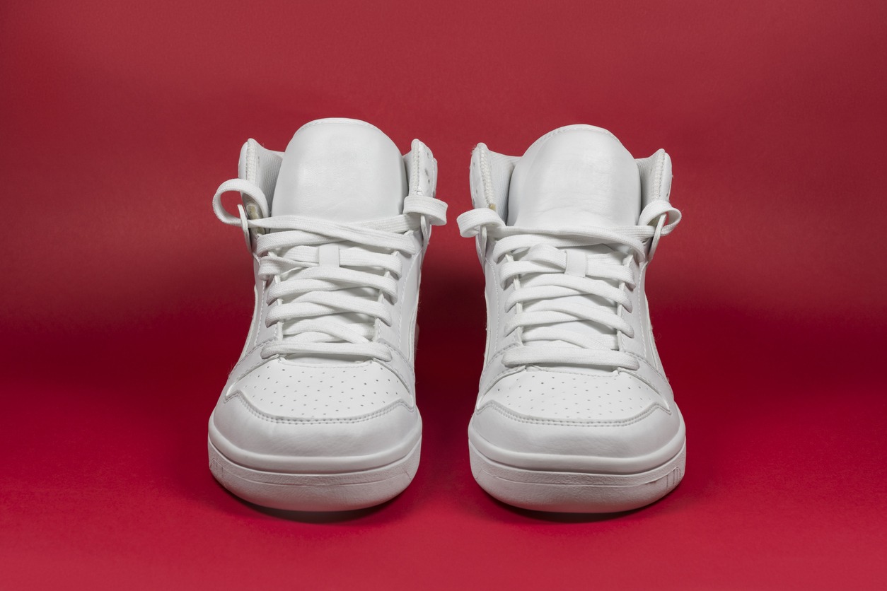 Modern, stylish, fashionable, high white sneakers on red background.