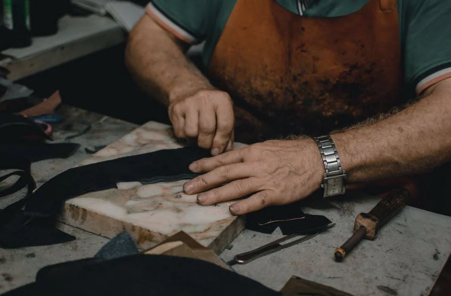 A shoemaker cutting leather