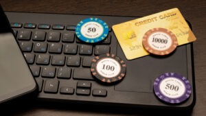 Online casino theme. Smartphone, credit card and poker chips lie on the computer keyboard
