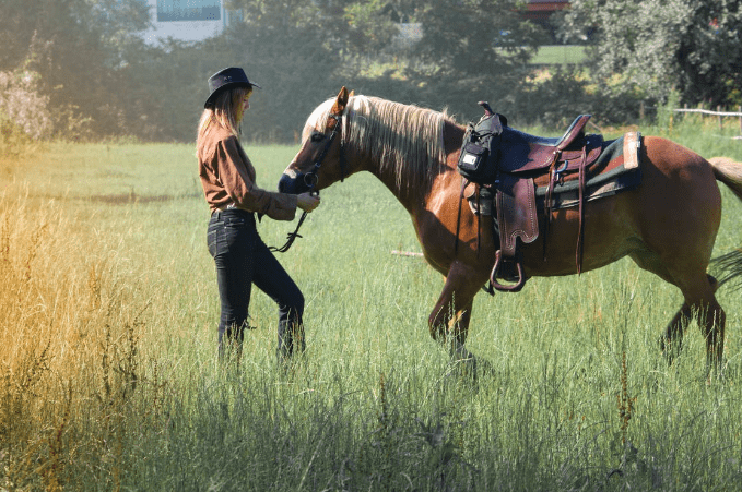 adult-woman-with-horse-on-farm-pasture