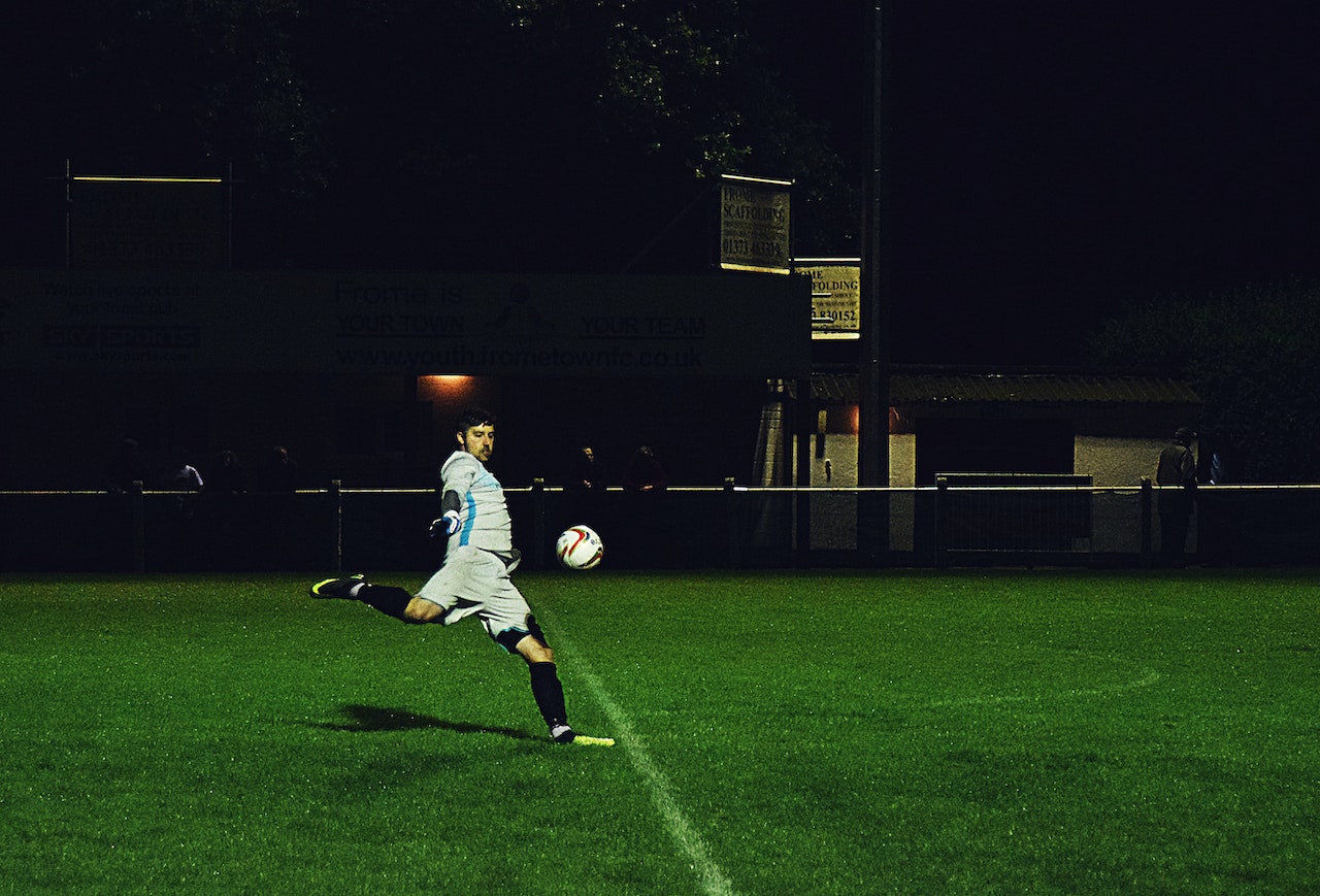 person kicks a soccer ball into the field